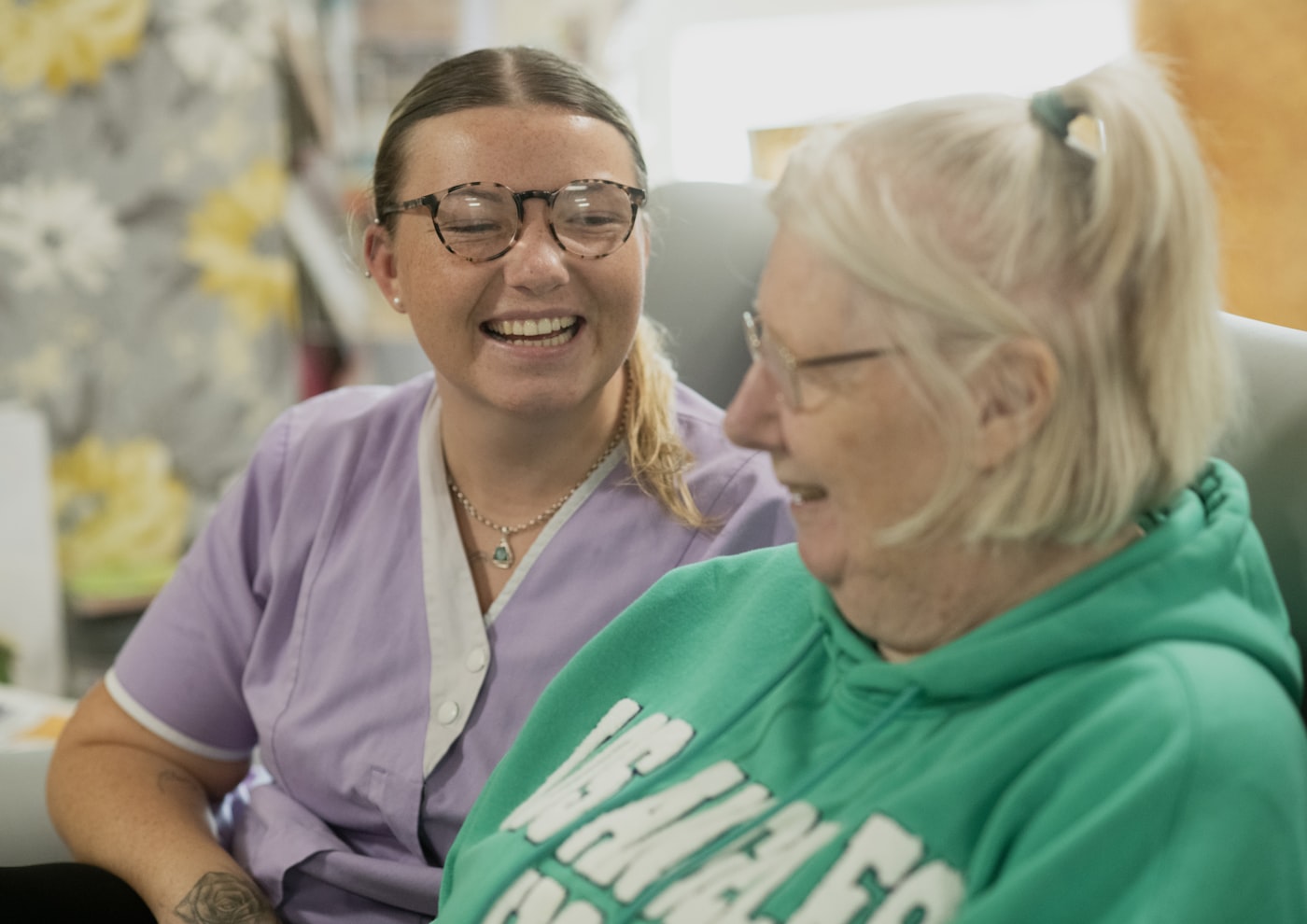 Braewood caregiver and an older woman laughing together at home