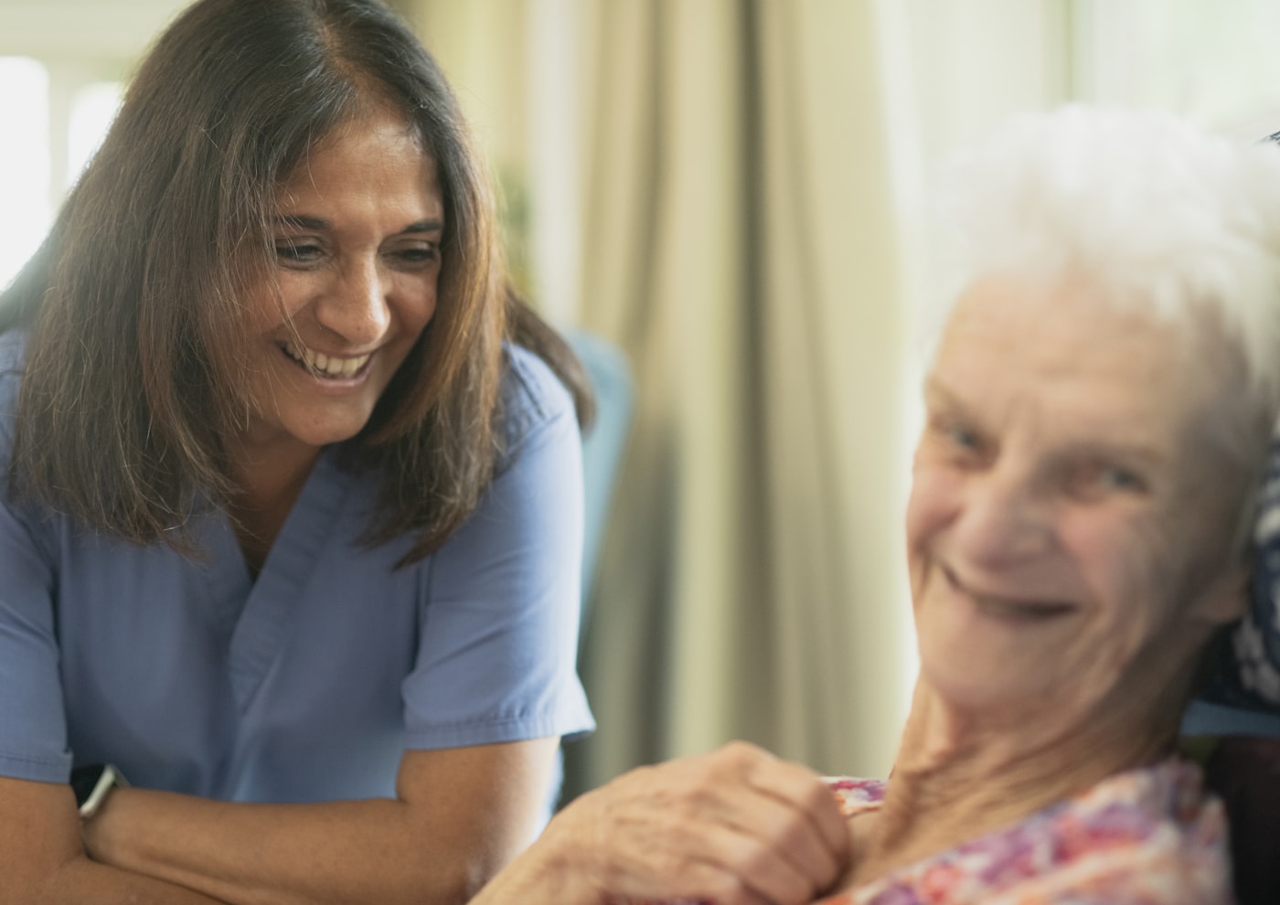Home health nurse smiling with an elderly patient at home